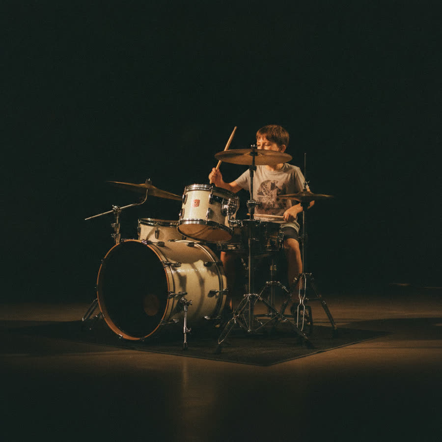 A child playing a drum kit